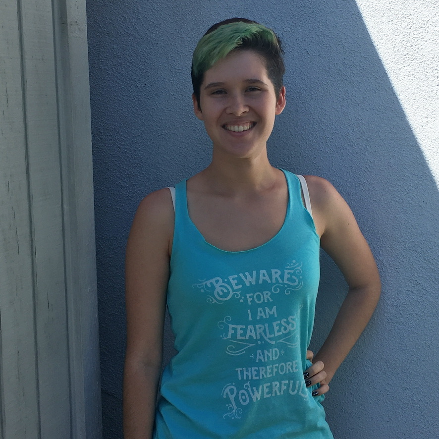 Photograph of a young woman wearing a light blue tank top with the "Beware; for I Am Fearless" design from BumbleBess.com